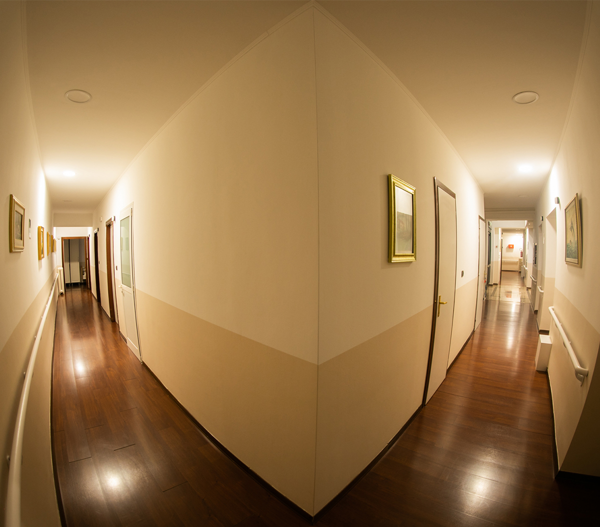 Corridoio con quadri e pavimento in legno